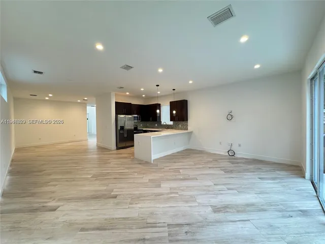a view of kitchen with kitchen island a sink appliances and cabinets