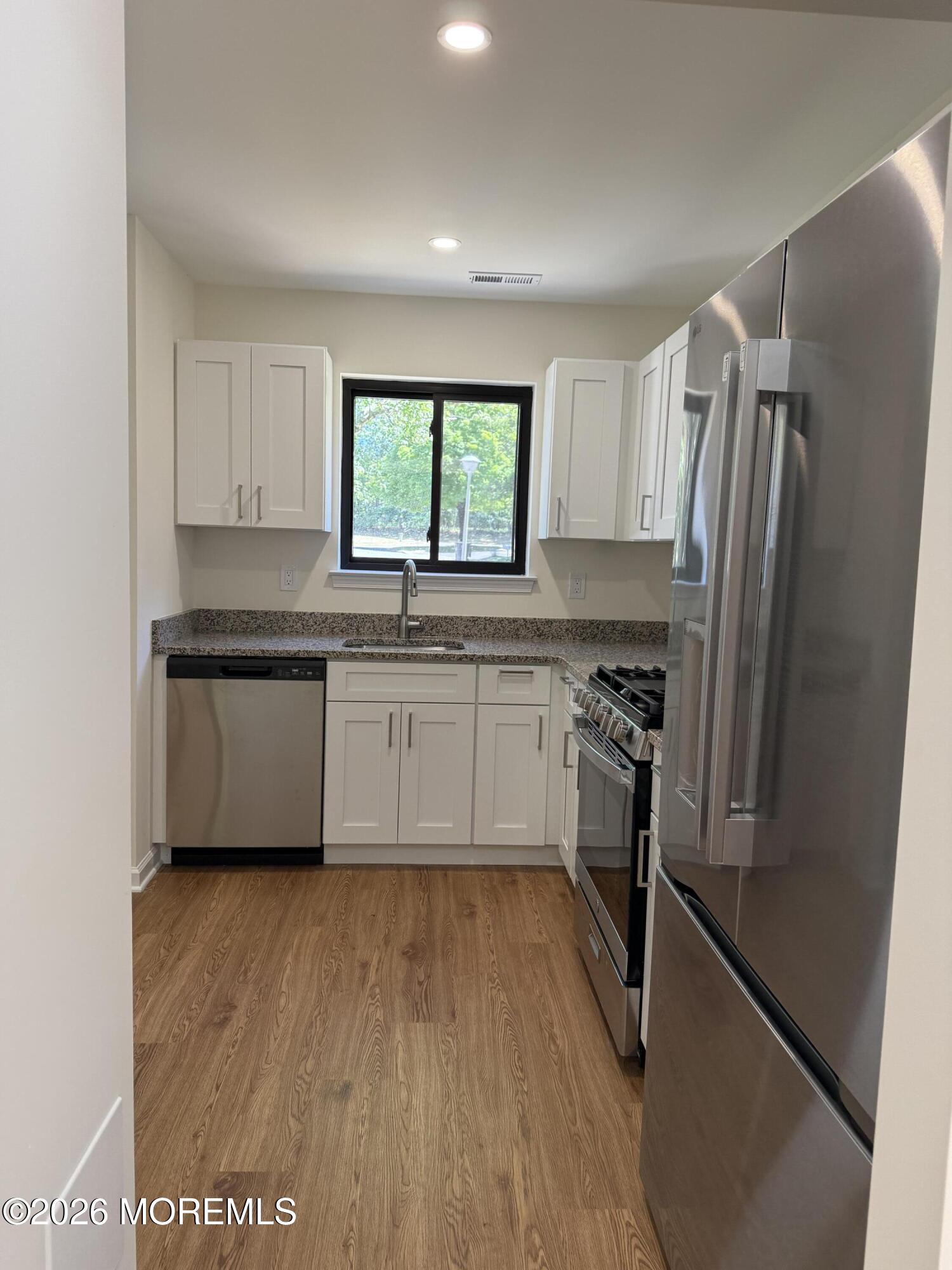5 Canary Circle Howell, NJ 07731 - Photo 6 of 32 a kitchen with a sink wooden floor and stainless steel appliances