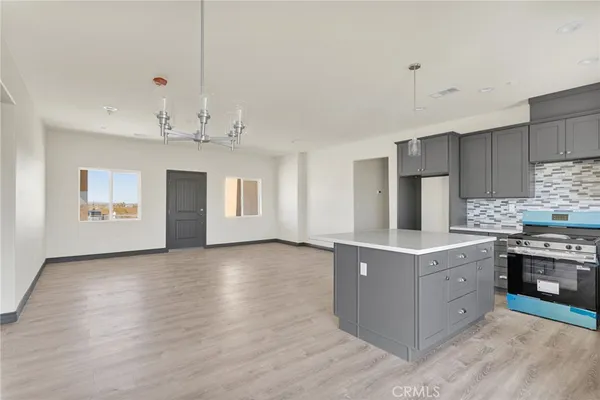 a kitchen with stainless steel appliances granite countertop a sink a stove and a refrigerator