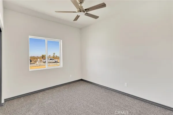 an empty room with a window and a fan