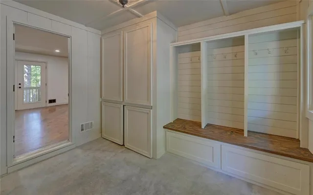 an empty room with closet and a chandelier fan