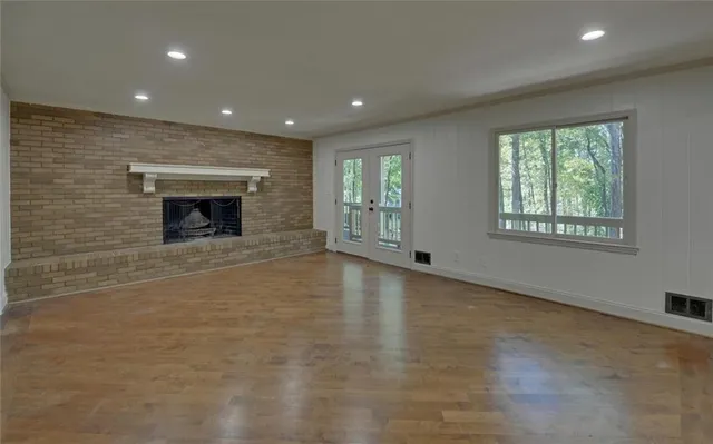 an empty room with windows and fireplace
