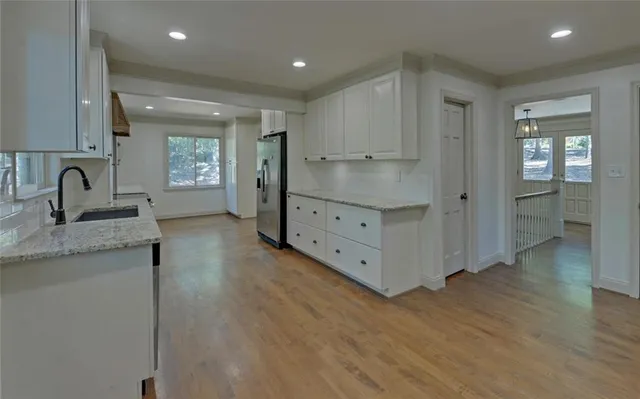 a kitchen with granite countertop white cabinets and sink