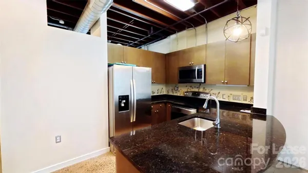 a kitchen with stainless steel appliances granite countertop a sink refrigerator and stove