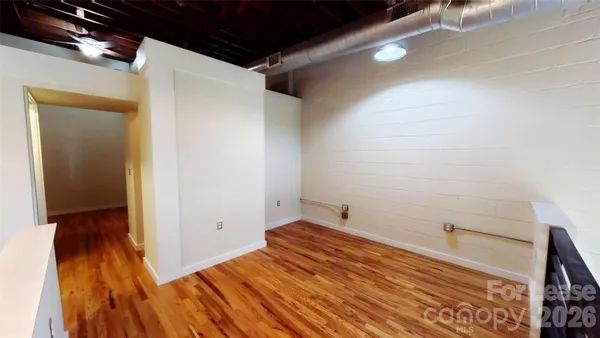 a view of empty room with wooden floor