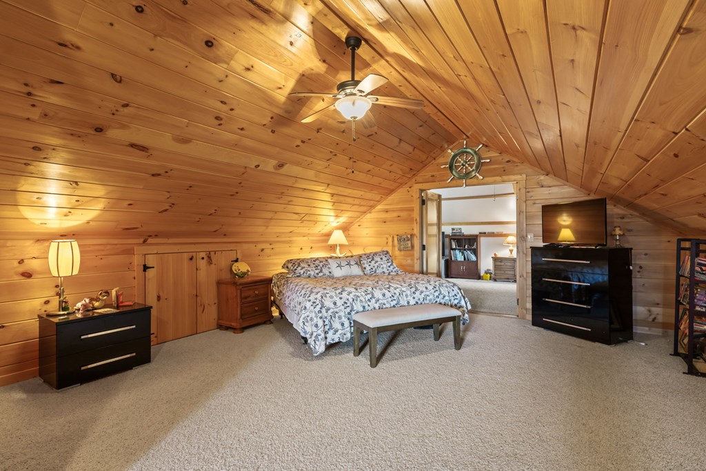 45 Turning Lay Road Morganton, GA 30560 - Photo 33 of 48 a spacious bedroom with a bed and a chandelier