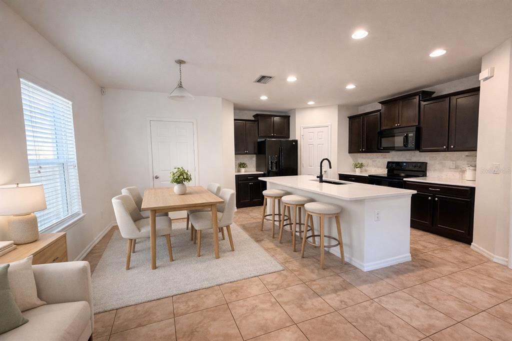 4747 Chatterton Way Riverview, FL 33578 - Photo 3 of 24 a living room with stainless steel appliances kitchen island granite countertop a dining table chairs and a kitchen view