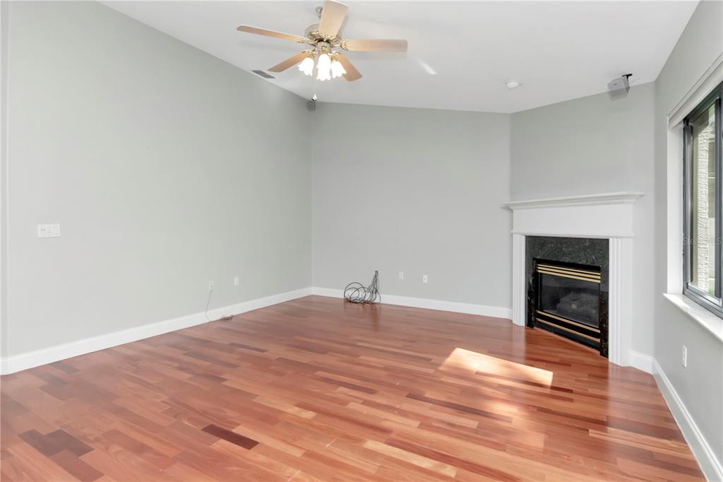 4938 Yellowstone Drive New Port Richey, FL 34655 - Photo 14 of 51 a view of empty room with wooden floor and kitchen view