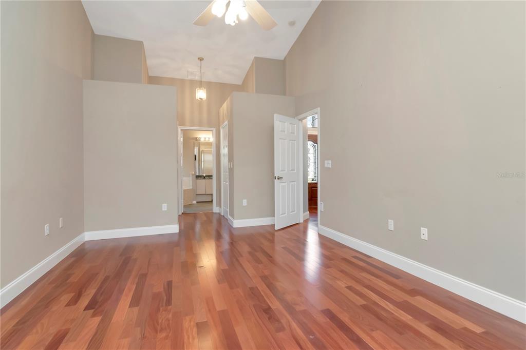 4938 Yellowstone Drive New Port Richey, FL 34655 - Photo 17 of 51 a view of an empty room with wooden floor and a ceiling fan
