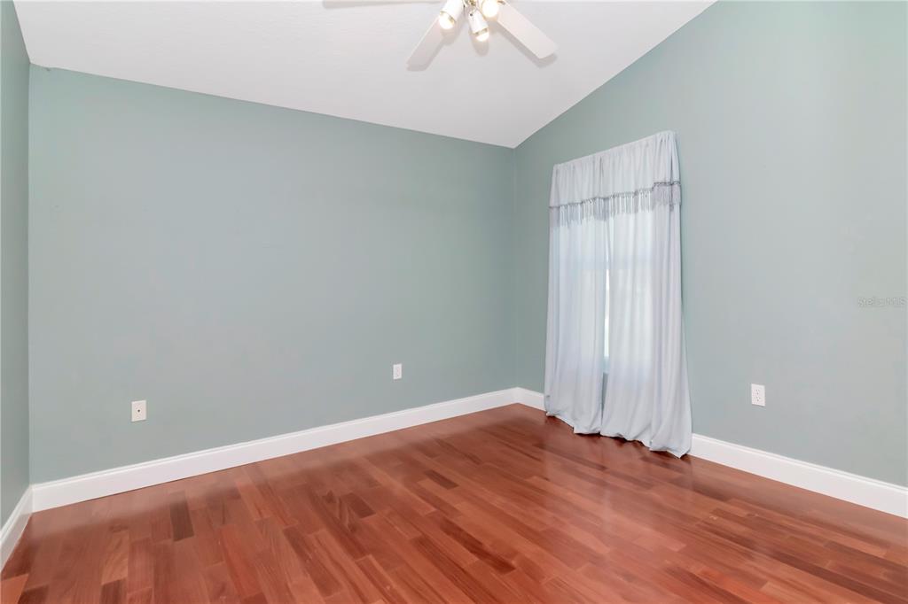 4938 Yellowstone Drive New Port Richey, FL 34655 - Photo 23 of 51 an empty room with wooden floor and windows