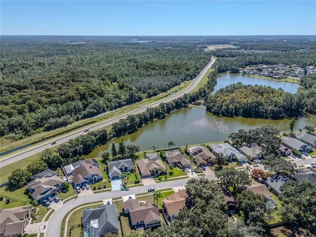 an aerial view of residential houses with outdoor space and lake view