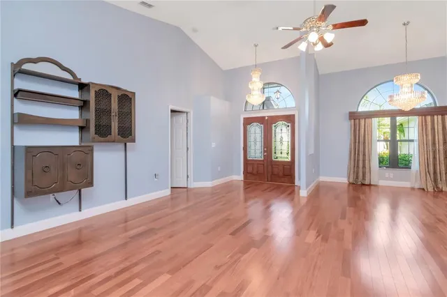 a view of an empty room with a window and wooden floor
