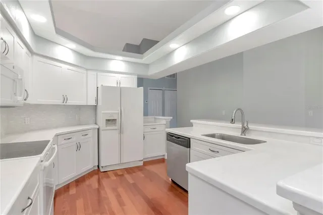 a kitchen with a sink cabinets stainless steel appliances and a window