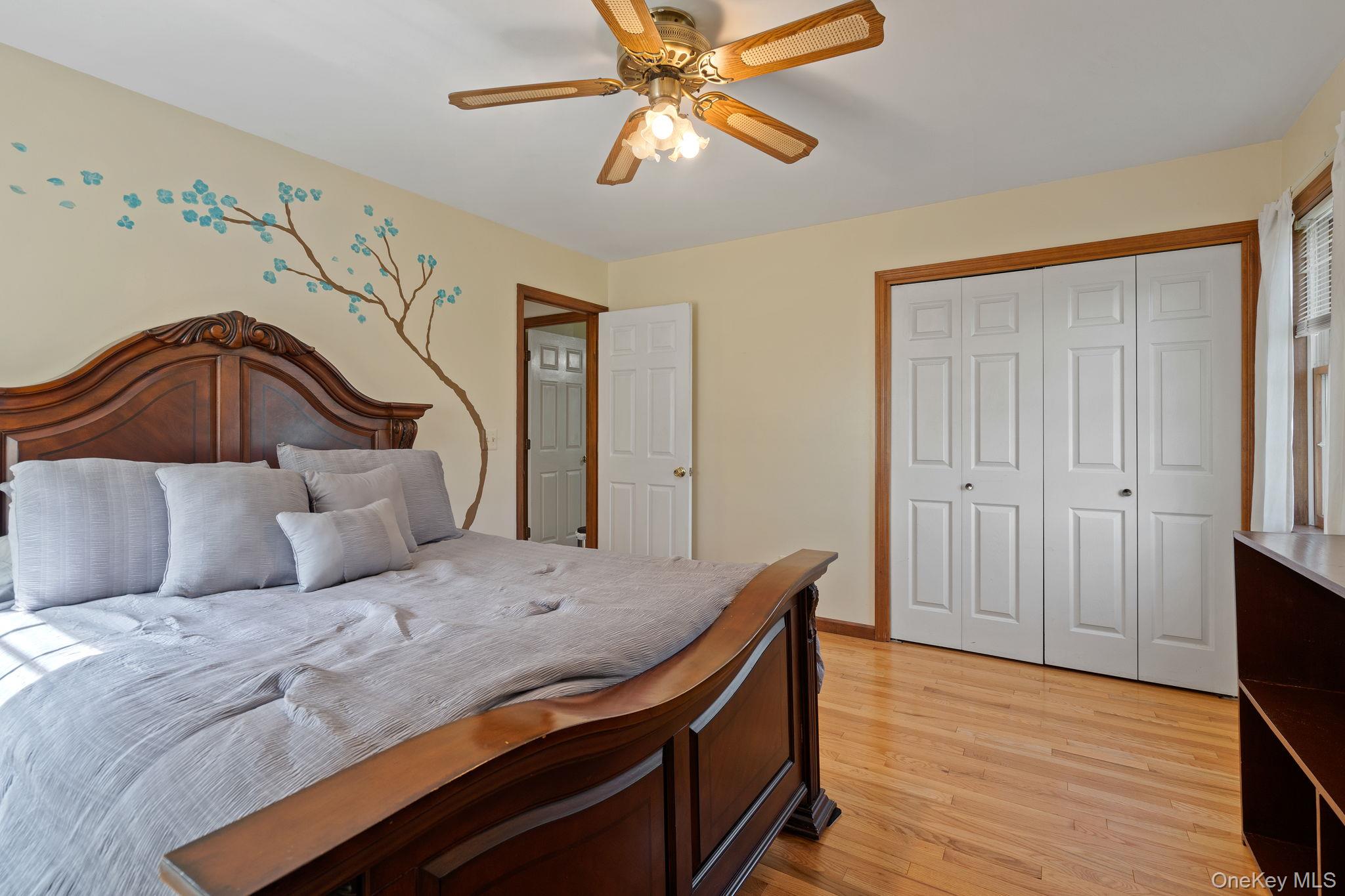 140 Burnt Corners Road Middletown, NY 10940 - Photo 38 of 50 Bedroom with wood-finish flooring, a ceiling fan with light fixture, double bi-fold closet doors, and a window with blinds