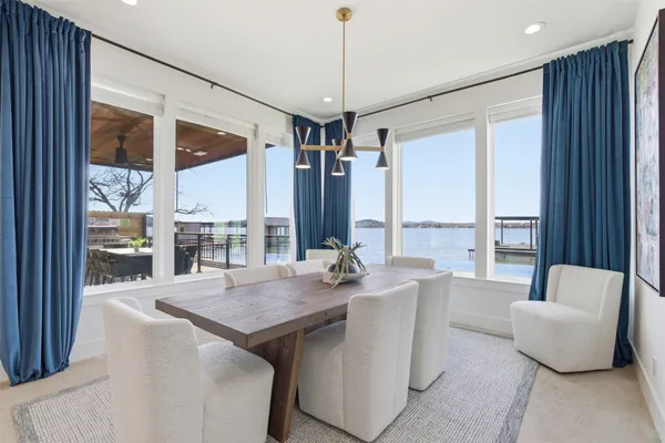 a dining room with furniture a large window and a chandelier