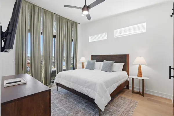 a bedroom with a bed table and a large mirror