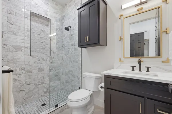 a bathroom with a sink a toilet and shower