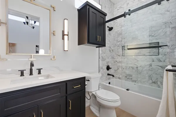a bathroom with a sink a toilet and shower