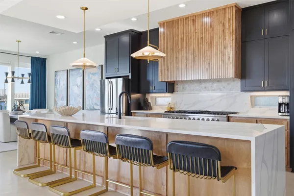 a kitchen with stainless steel appliances granite countertop a stove a sink a dining table and chairs