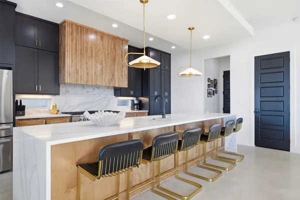 a kitchen with stainless steel appliances granite countertop a sink and a refrigerator