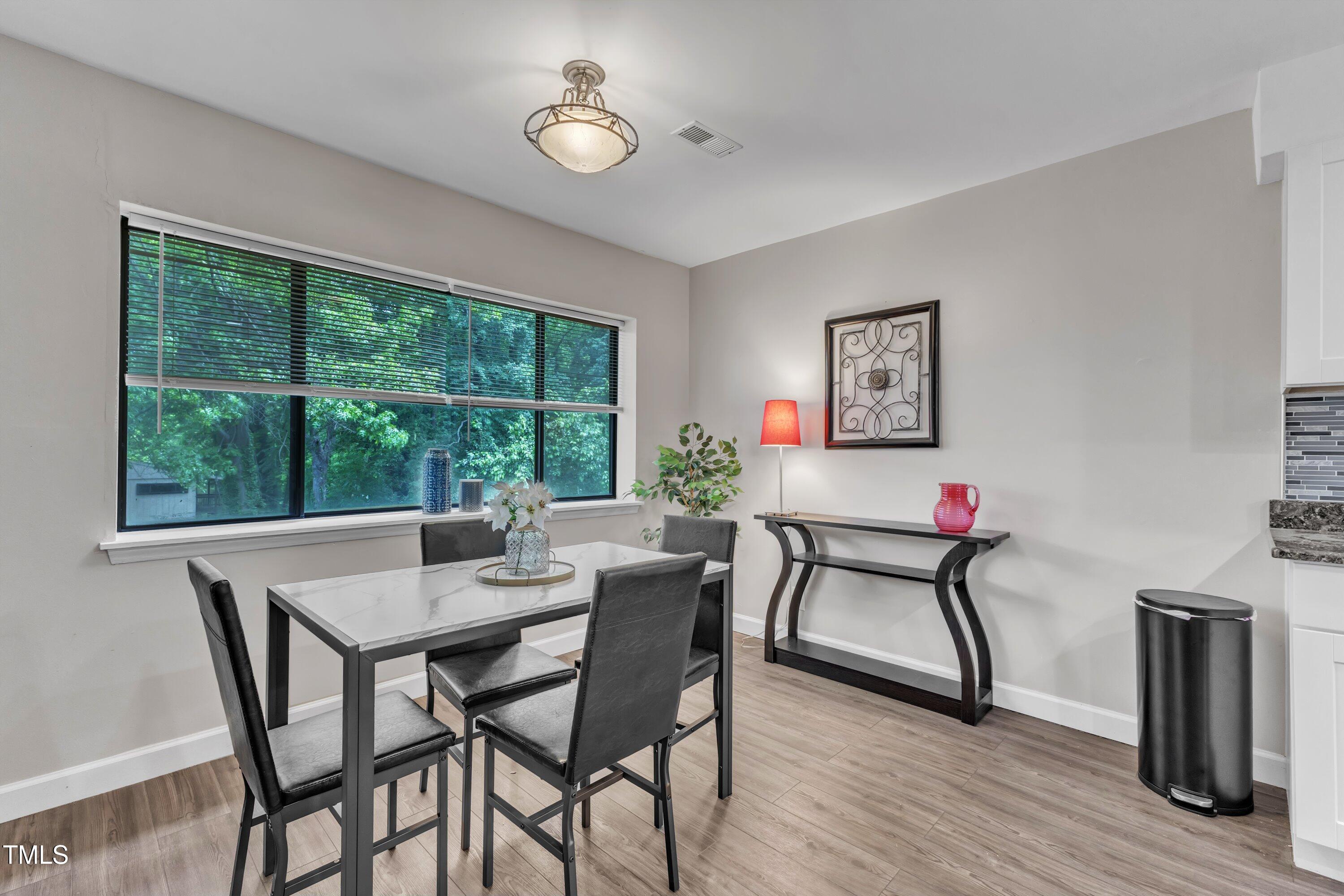 5022 Flint Ridge Place Raleigh, NC 27609 - Photo 11 of 32 a view of a dining room with furniture window and wooden floor
