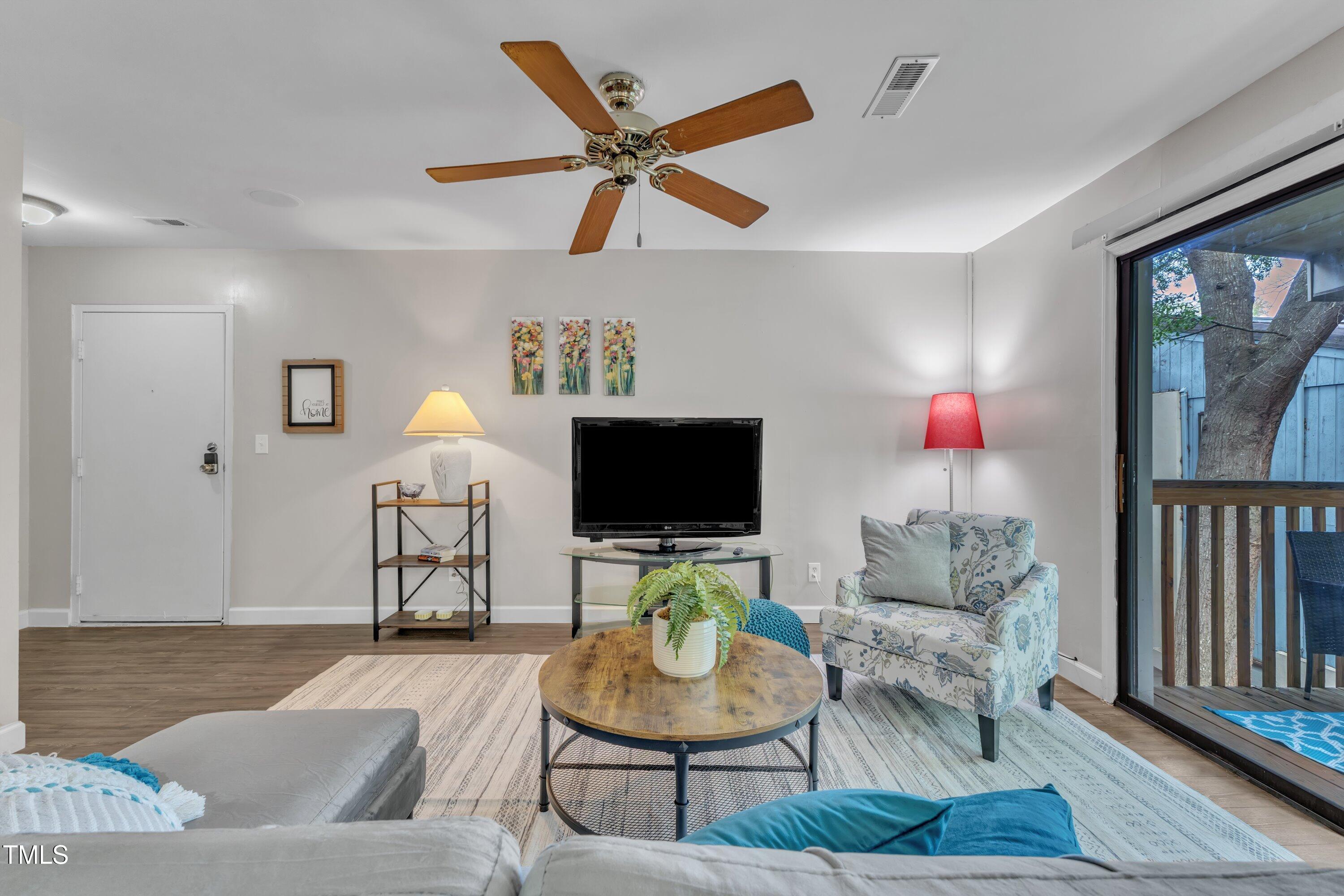 5022 Flint Ridge Place Raleigh, NC 27609 - Photo 13 of 32 a living room with furniture and a flat screen tv with wooden floor