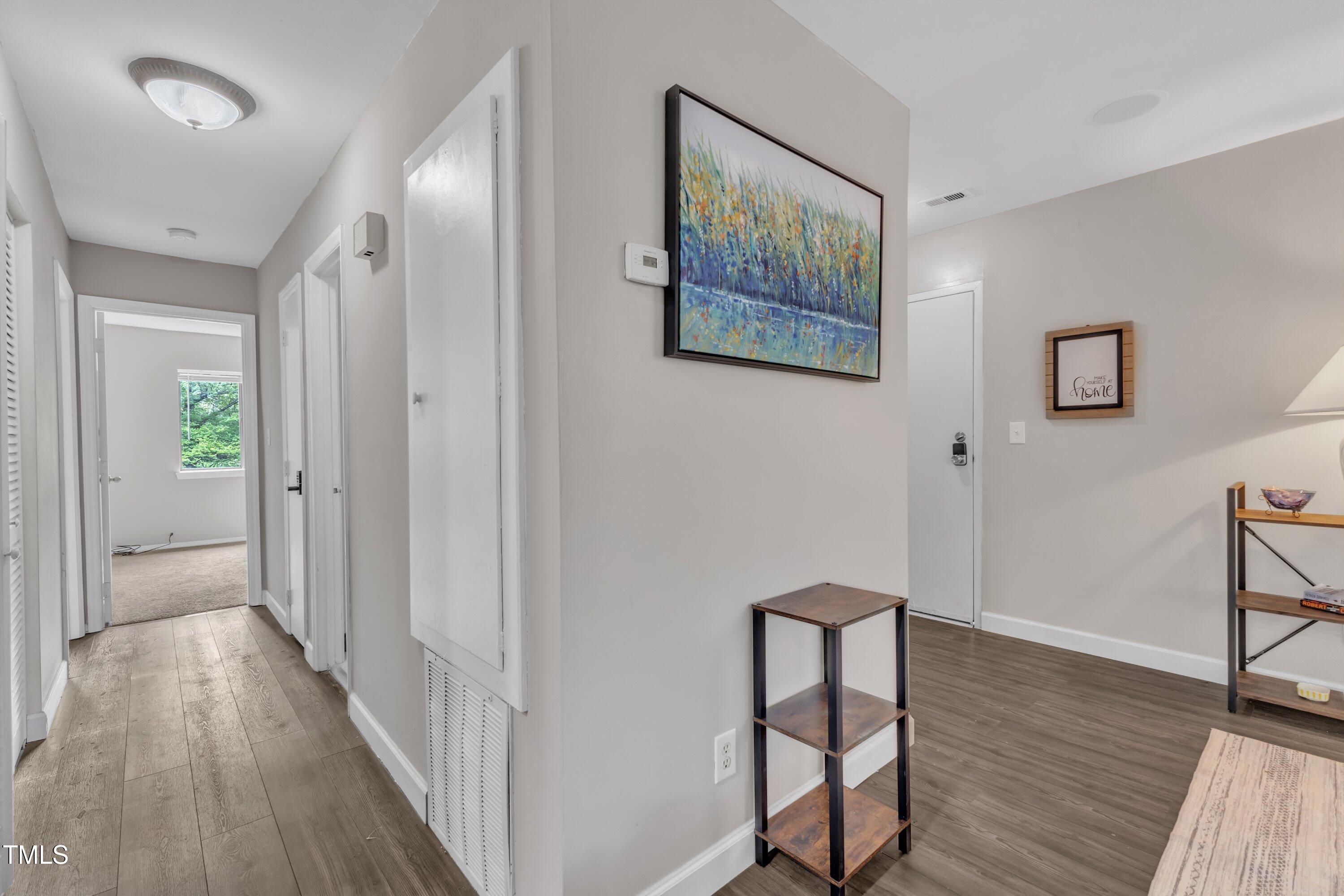 5022 Flint Ridge Place Raleigh, NC 27609 - Photo 14 of 32 a view of a hallway with wooden floor and staircase