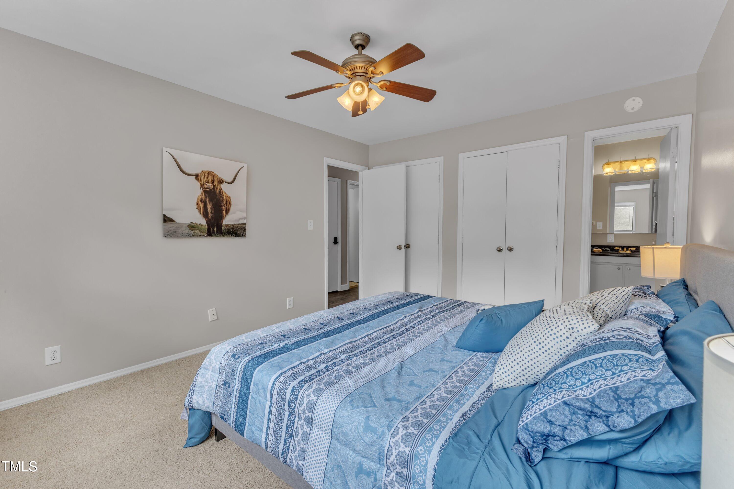 5022 Flint Ridge Place Raleigh, NC 27609 - Photo 17 of 32 a bedroom with a bed and a chandelier