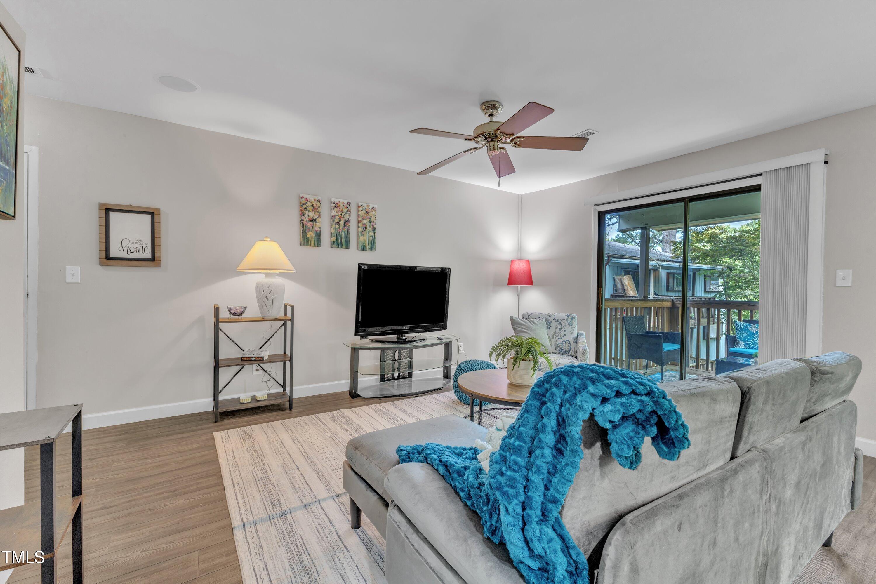 5022 Flint Ridge Place Raleigh, NC 27609 - Photo 2 of 32 a living room with furniture a flat screen tv and a large window