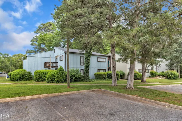 a view of a house with a big yard and large trees