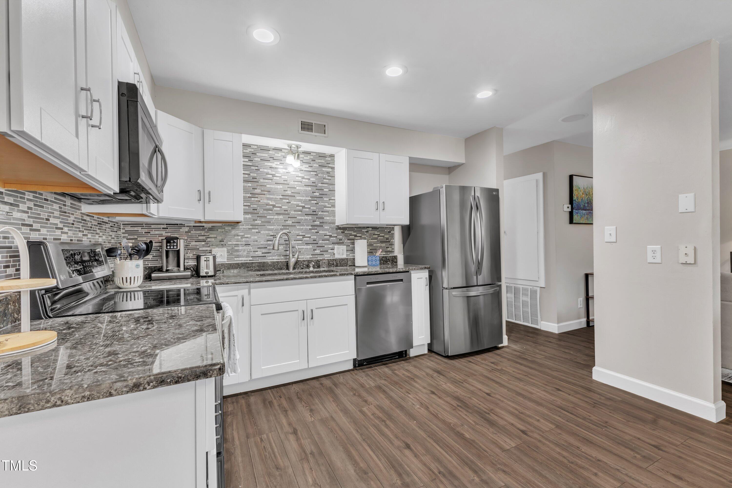 5022 Flint Ridge Place Raleigh, NC 27609 - Photo 8 of 32 a kitchen with a refrigerator sink and cabinets