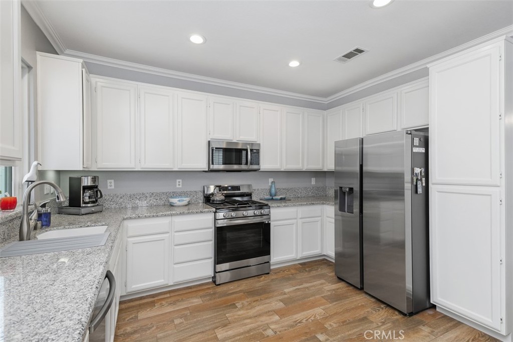 28208 Meadowsweet Drive Menifee, CA 92584 - Photo 11 of 55 a kitchen with stainless steel appliances granite countertop a refrigerator sink and stove