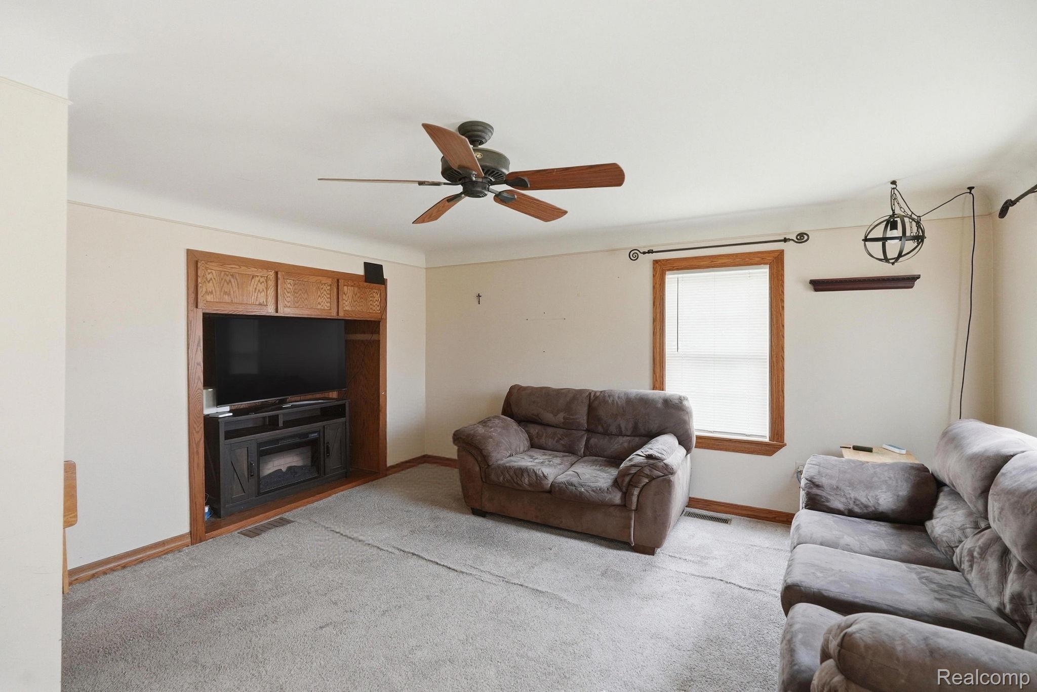 49777 Card Road Macomb, MI 48044 - Photo 6 of 18 Living room featuring carpet floors and a ceiling fan