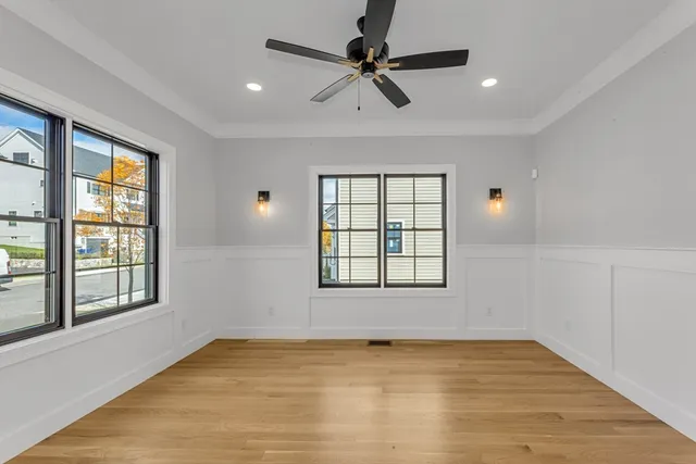 a view of an empty room with a window and wooden floor