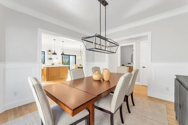 a dining room with furniture a chandelier and wooden floor