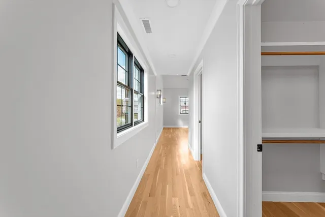 a view of a hallway with wooden floor and staircase
