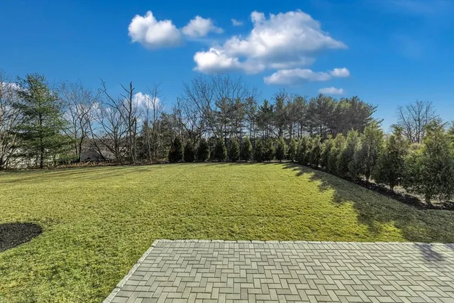 a large kitchen with stainless steel appliances kitchen island granite countertop a stove a sink a refrigerator and white cabinets next to a window