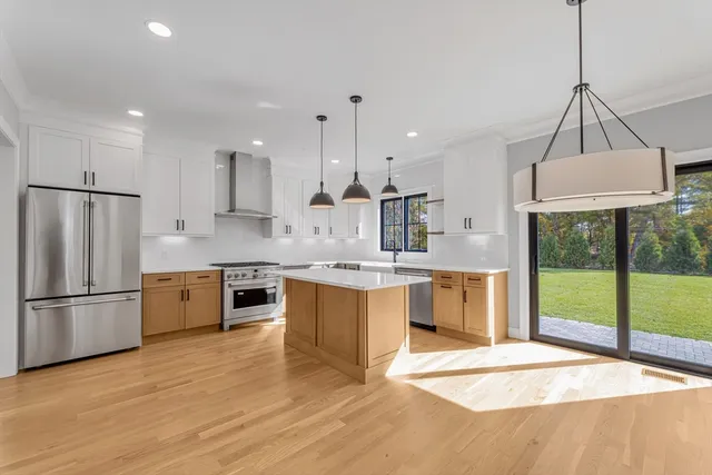 a large kitchen with granite countertop a large counter top a sink stainless steel appliances and cabinets