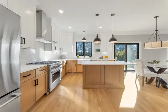 a view of a yard in front of a house with plants and large tree