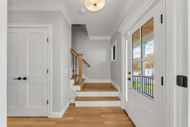 a view of a hallway with wooden floor and entryway