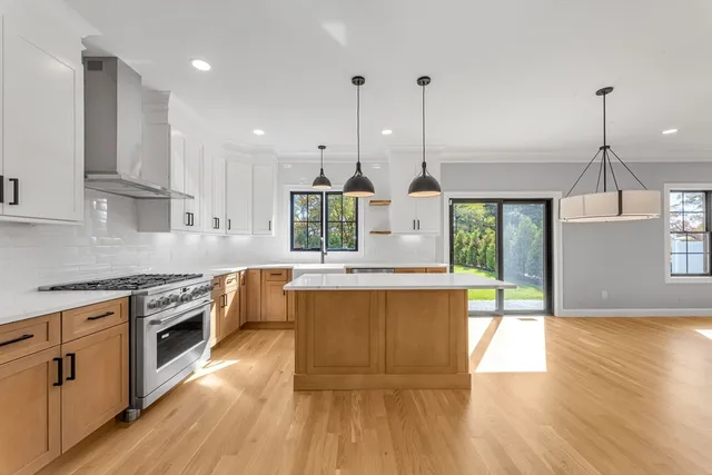 a kitchen with stainless steel appliances granite countertop wooden floor sink stove and wooden floor