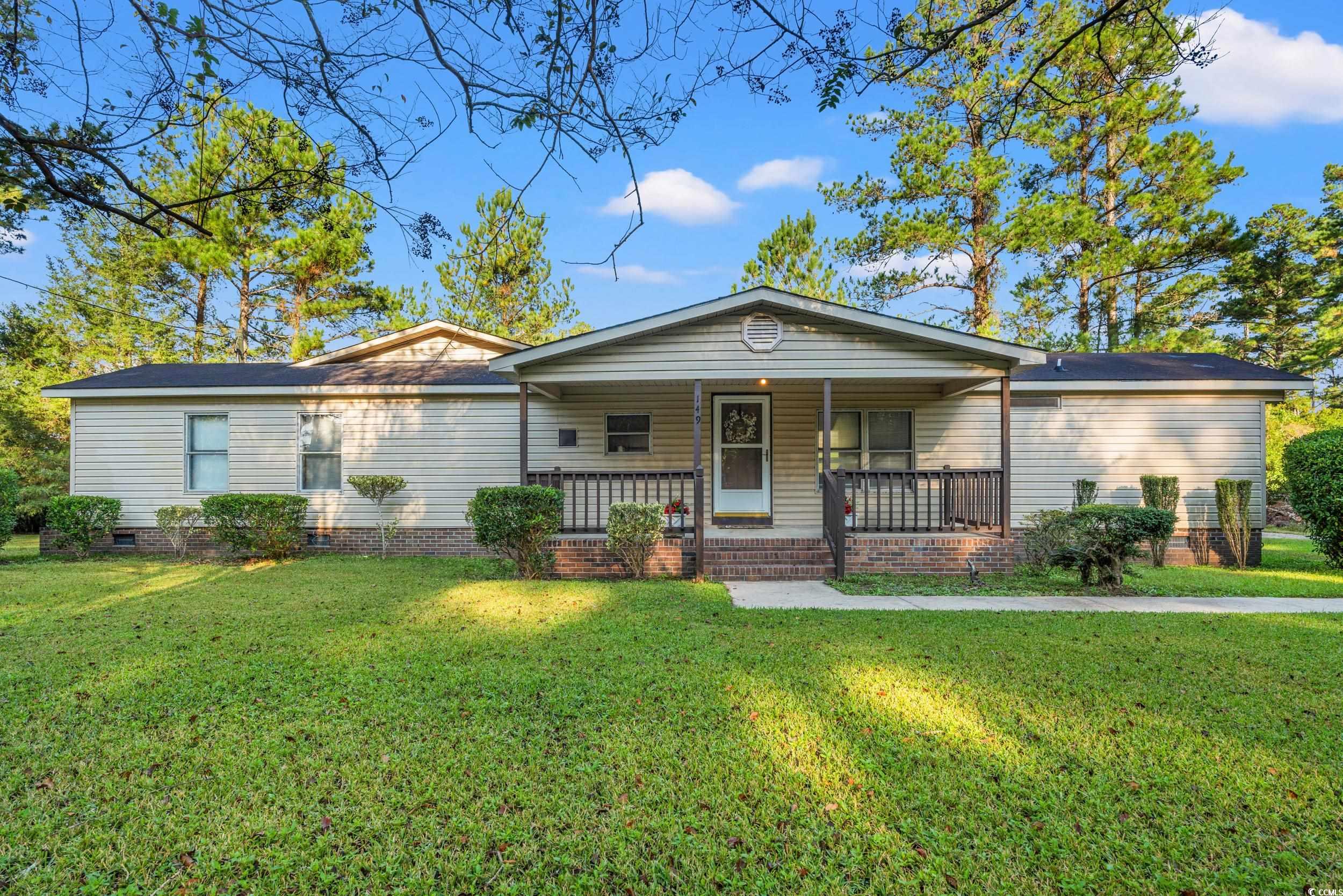 View of front of house with a porch, a front yard, and crawl space