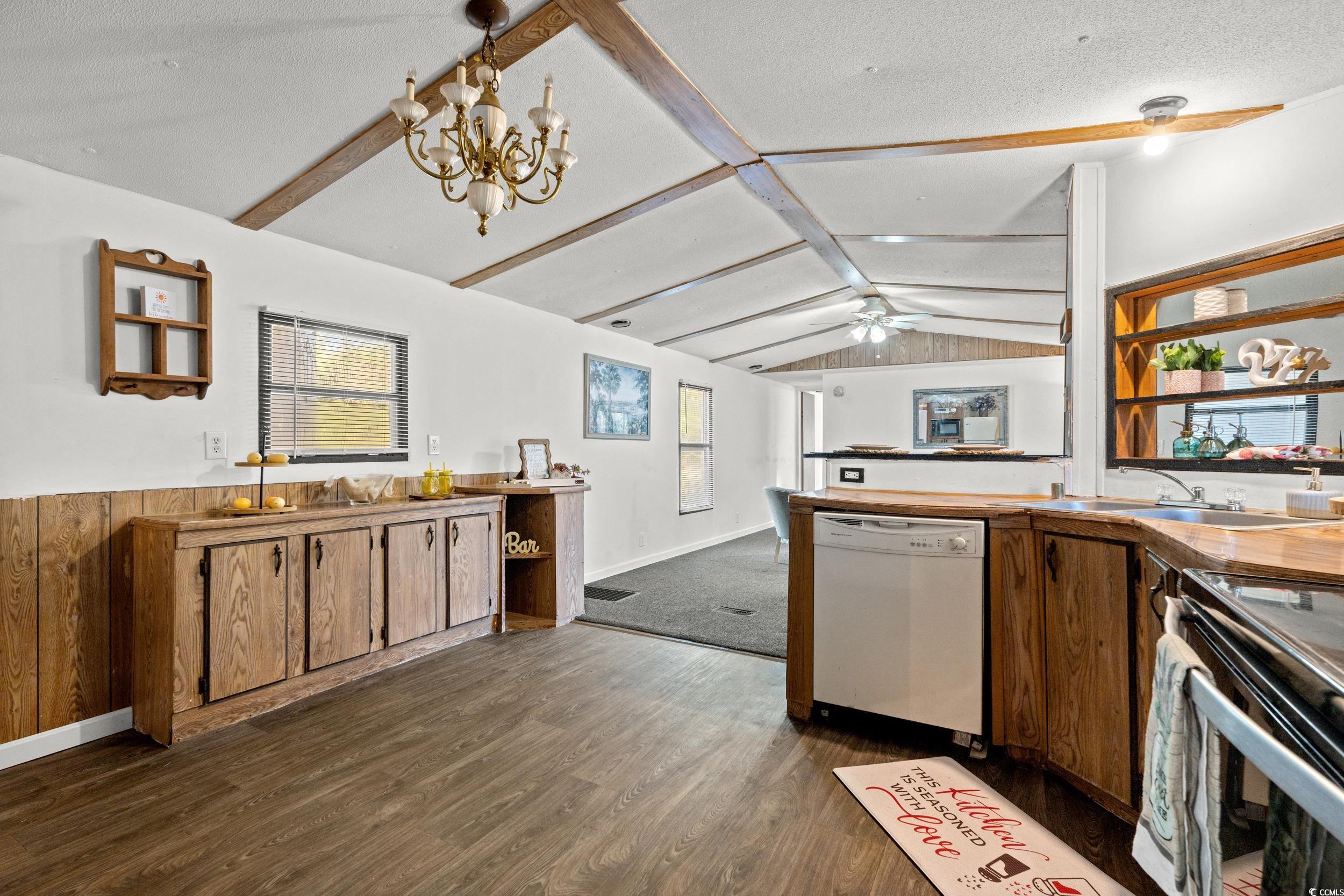 149 William Street Loris, SC 29569 - Photo 12 of 40 Kitchen featuring white dishwasher, dark wood-type flooring, hanging light fixtures, a chandelier, and a peninsula