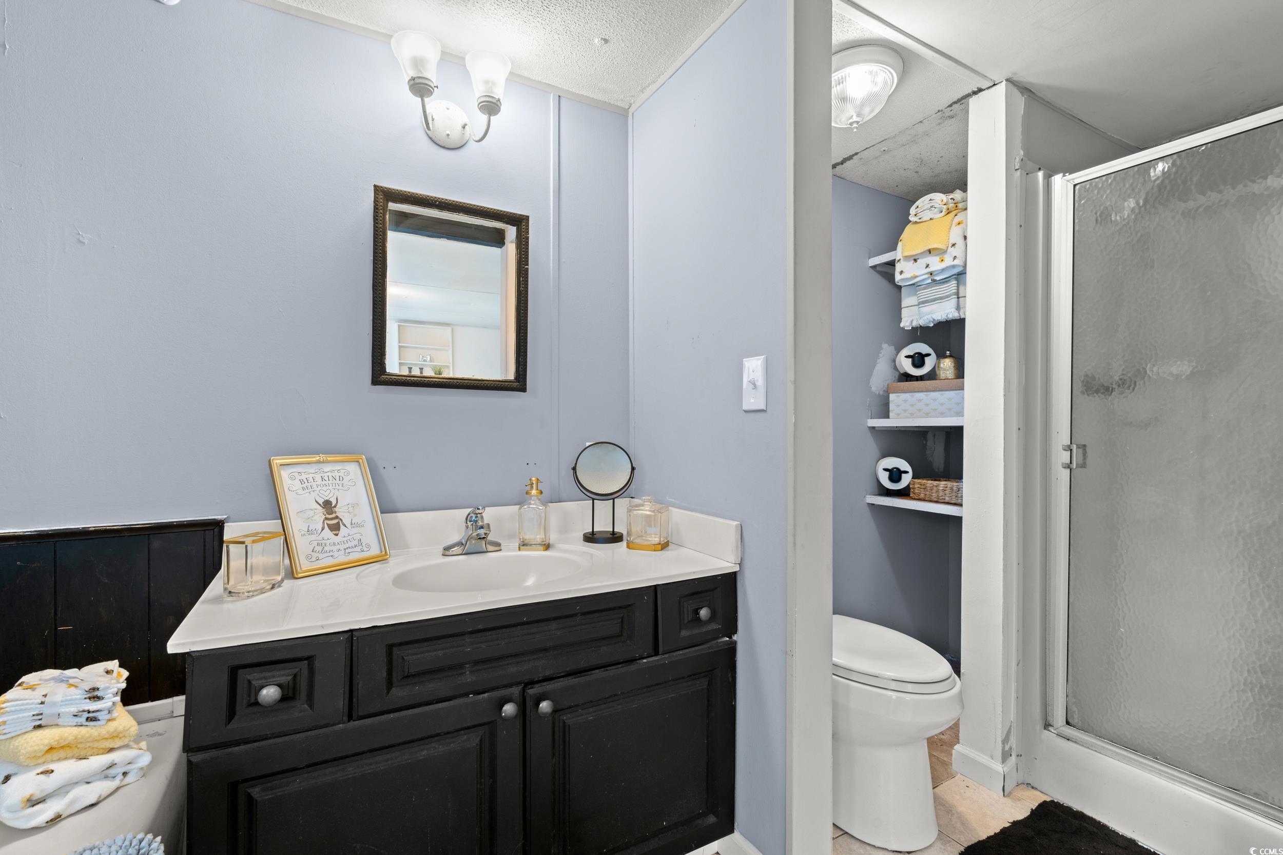 149 William Street Loris, SC 29569 - Photo 21 of 40 Full bathroom featuring vanity, a stall shower, and a textured ceiling