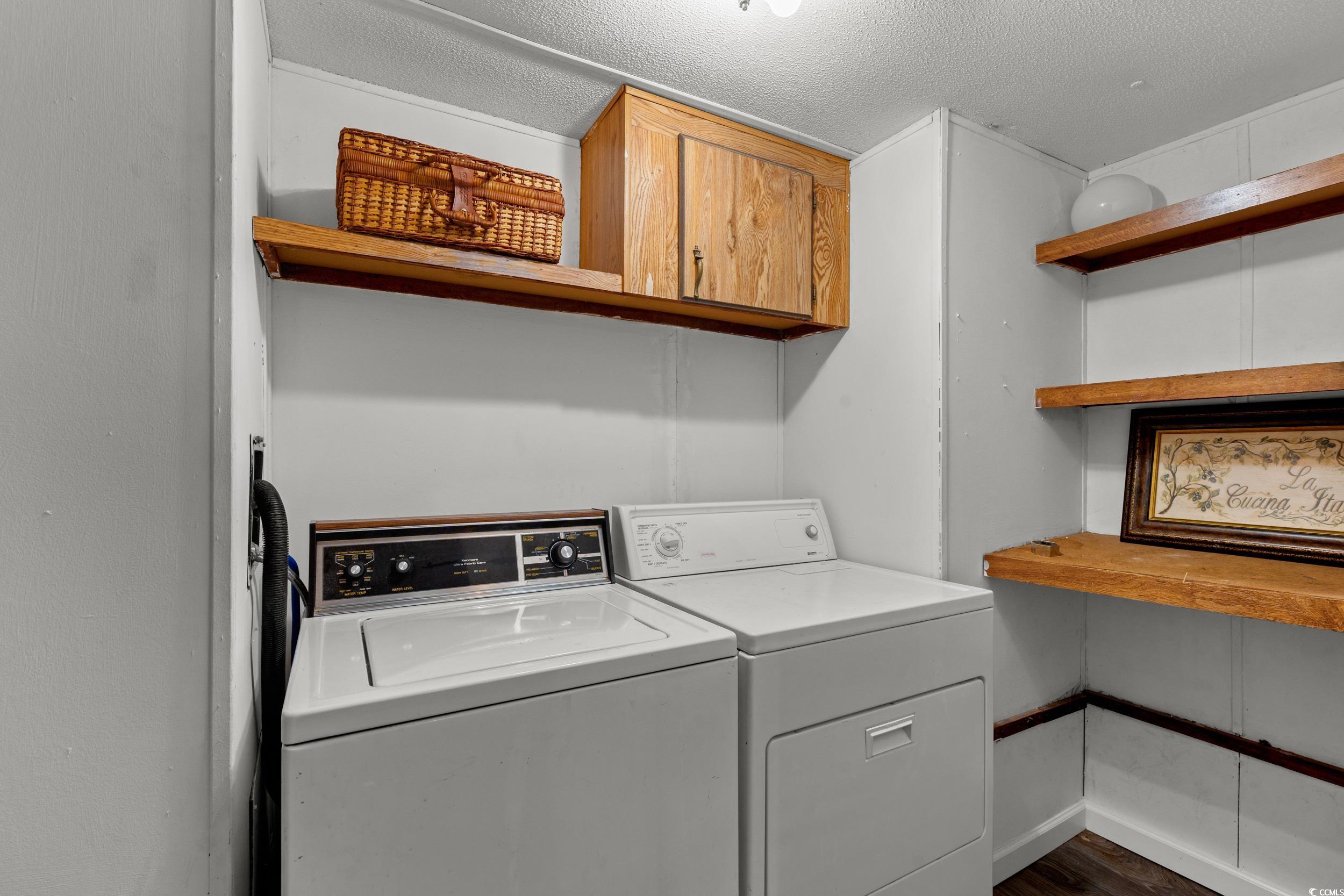 149 William Street Loris, SC 29569 - Photo 28 of 40 Laundry area with washing machine and clothes dryer, a textured ceiling, dark wood finished floors, and cabinet space