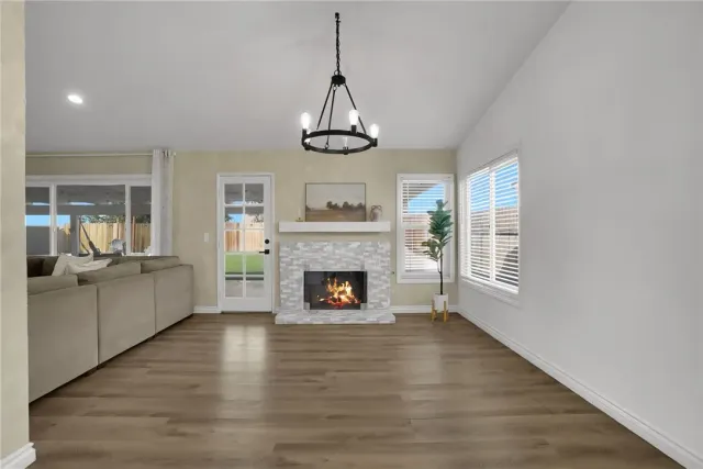 a view of a livingroom with wooden floor a fireplace and windows