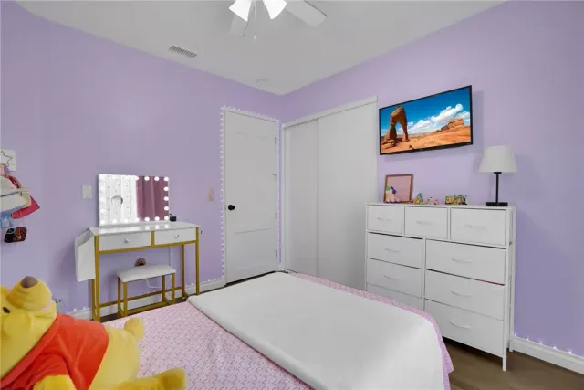 a bedroom with a bed a desk and dresser