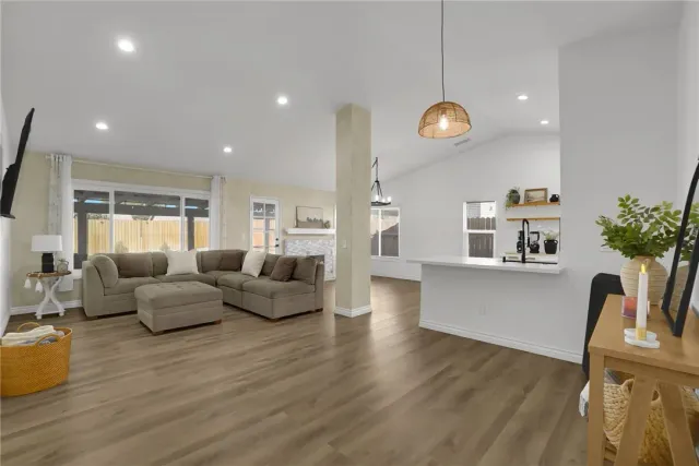 a living room with furniture a window and wooden floor