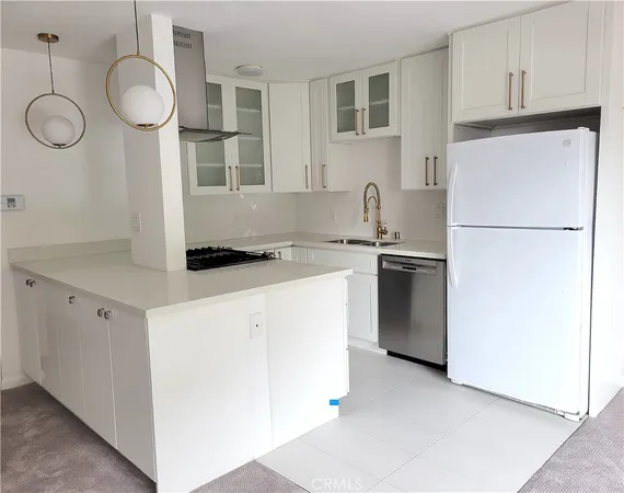 a kitchen with a refrigerator a stove top oven and a sink