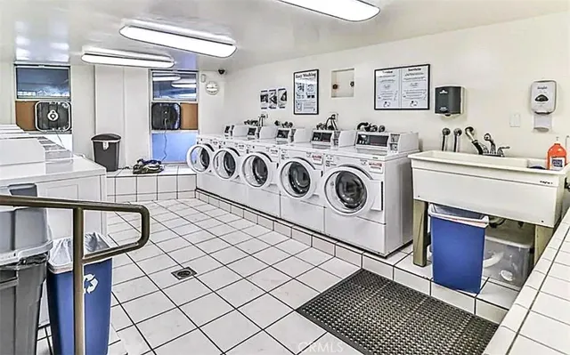a utility room with dryer washer and a view of living room